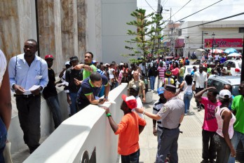 Extranjeros acuden en masas a Gobernación de Santiago a retirar carnés
