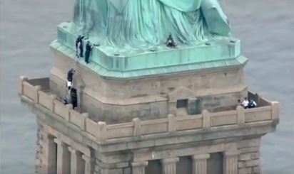 Mujer intenta escalar la base de la Estatua de la Libertad